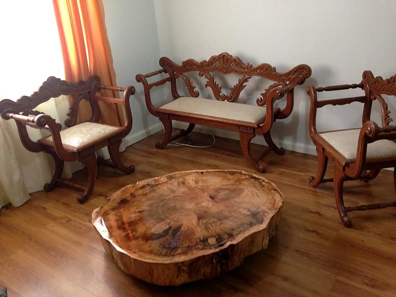 Mesa de centro grande de tronco em sala com cadeiras entalhadas
